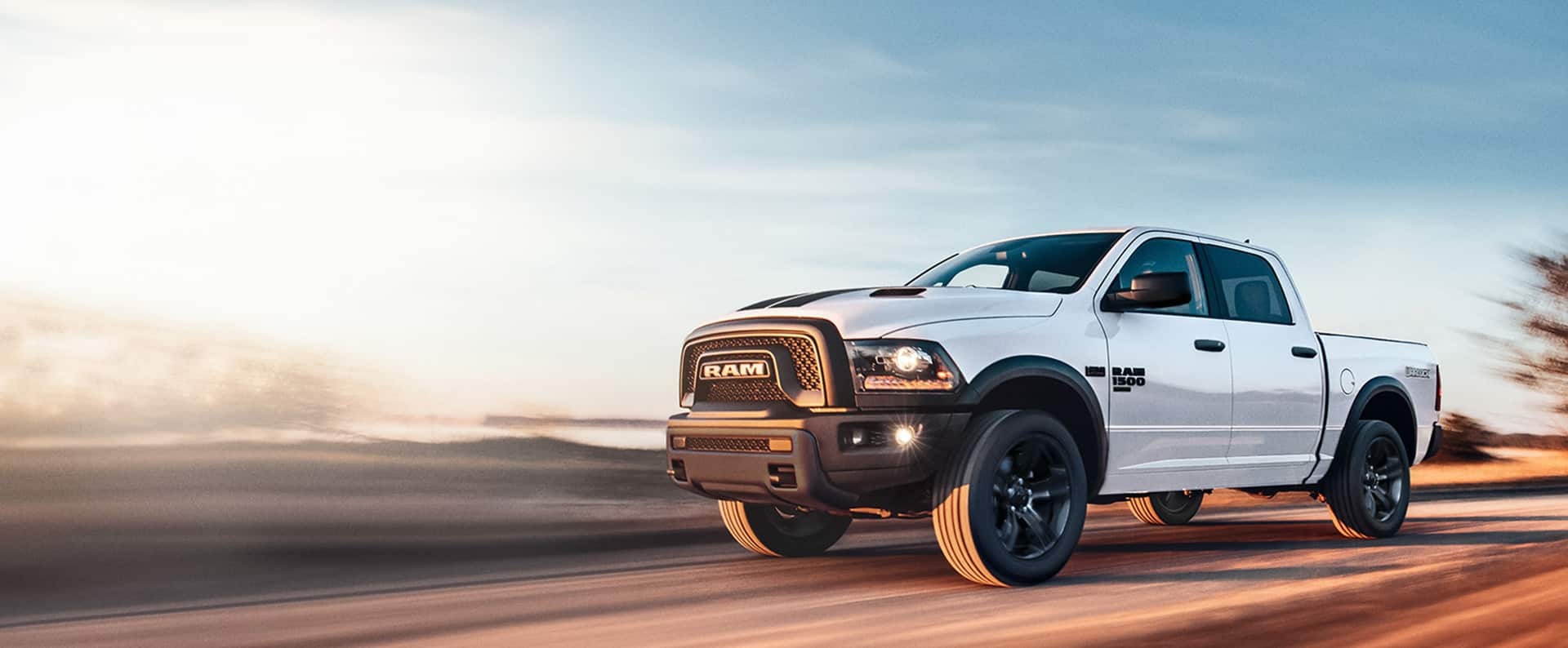 A RAM 1500 Classic driving quickly down a road.